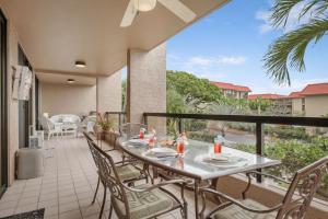 a patio with a table and chairs on a balcony at Kona Pacific B-308 in Kailua-Kona