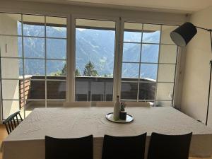 a dining room table with a view of a mountain at A lovely two bedrooms flat in Braunwald
