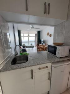 eine Küche mit Spüle und Mikrowelle in der Unterkunft Sunrise in Calpe + 10 Fotos