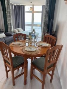 einen Esstisch mit 4 Stühlen, einem Tisch und einer Couch in der Unterkunft Sunrise in Calpe