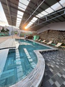 une grande piscine avec des chaises dans un bâtiment dans l'établissement Villa Healing Home Hồ Bơi Nước Nóng, à Trai Mat