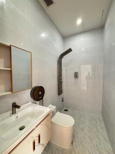 une salle de bains blanche avec toilettes et lavabo dans l'établissement Villa Healing Home Hồ Bơi Nước Nóng, à Trai Mat 33 autres photos