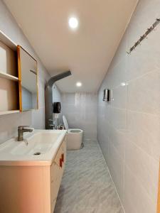 une salle de bain avec un lavabo et des toilettes dans l'établissement Villa Healing Home Hồ Bơi Nước Nóng, à Trai Mat