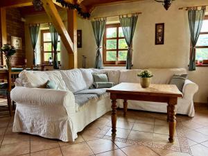 a living room with a white couch and a table at Chalupa pri Ukoch s wellness, Bílé Karpaty in Matěk