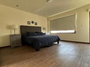 San José el AltoにあるSwiss Houseのウッドフロアのベッドルーム1室(ベッド1台、窓付)