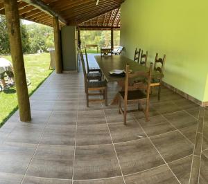 a dining room with a table and chairs on a tile floor at Chácara Pimenta Vermelha in Socorro