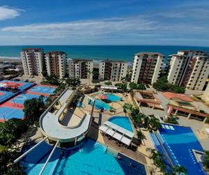 an aerial view of a resort with pools and the ocean at Playa Almendro Resort - Tonsupa in Tonsupa