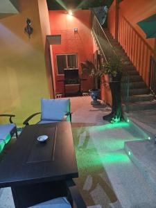 a living room with a table and a staircase with green lights at Chez Fatima et Hervé in Somone
