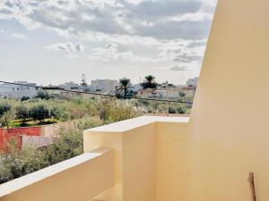a white balcony with a view of a city at Villa Olivier in Sakiet ez Zit