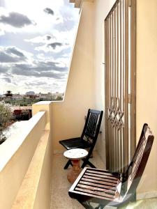 two chairs and a table on a balcony at Villa Olivier in Sakiet ez Zit