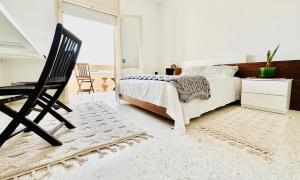 a bedroom with a bed and a chair and a window at Villa Olivier in Sakiet ez Zit