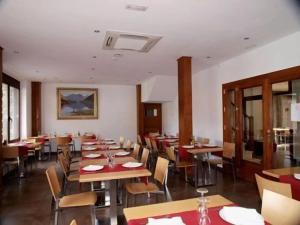 a dining room with wooden tables and chairs at Hotel Cases in Guingueta +3 photos