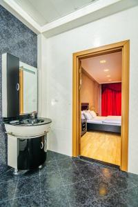 a bathroom with a sink and a room with a bed at Apartment on Leylek in Baku