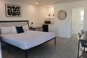 a bedroom with a large bed and a kitchen at Boulder City Inn in Boulder City