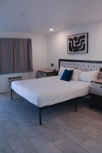 ボルダーシティにあるBoulder City Innのベッドルーム(白いシーツを使用した大型ベッド1台付)