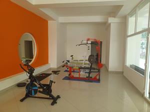 a room with an orange wall and a gym at Playa Almendro Resort - Tonsupa in Tonsupa +20 photos