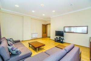 a living room with a couch and a table at Apartment on Leylek in Baku