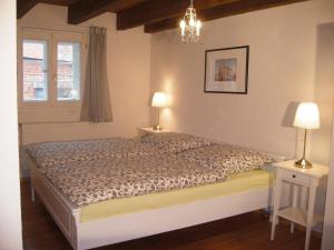 a bedroom with a bed and two lamps and a window at Ferienhaus Münzenberg 53 in Quedlinburg