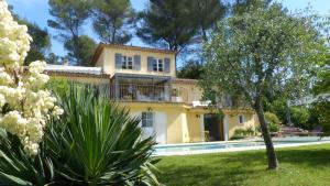 una grande casa gialla con piscina in un cortile di Ô Tilia d'Azur a Roquefort-les-Pins
