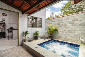 a swimming pool in a brick wall with potted plants at Casa Moreira in Pirenópolis