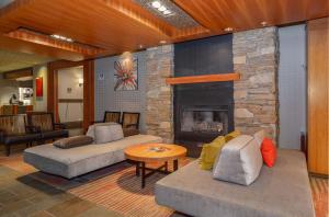 a living room with two couches and a fireplace at Listel Whistler, a Coast Hotel in Whistler