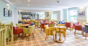 a bar with colorful chairs and tables in a restaurant at The Lakeland Kendal Hotel, Sure Hotel Collection by Best Western in Kendal