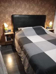 una camera da letto con un letto bianco e nero con due tavoli di Delpaulo a Olivet