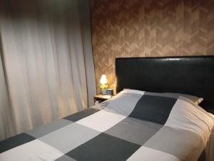 una camera da letto con un letto con un piumone bianco e nero di Delpaulo a Olivet