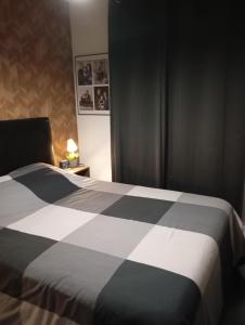 una camera con un letto bianco e nero e una lampada di Delpaulo a Olivet