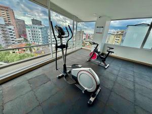 a gym with two exercise bikes in a building at Modern downtown apartment with gym and view in Quito