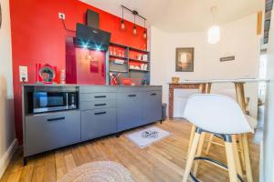 una cucina con una parete rossa e una sedia bianca di Escale de Dali - 1 Chambre a Brive-la-Gaillarde
