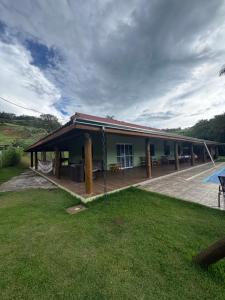 a house with a large deck and a patio at Chácara Pimenta Vermelha in Socorro