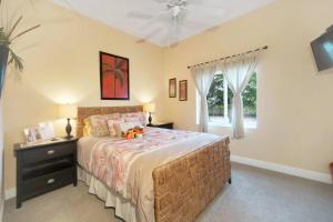 Un dormitorio con una cama grande y una ventana. en Tommy Bahama-style electric-heated pool home on Gulf-access canal - Villa Ellis, en Cabo Coral 13 fotos más