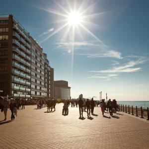 a group of people walking on a sidewalk near the ocean at Apartment Hertstraat in Ostend