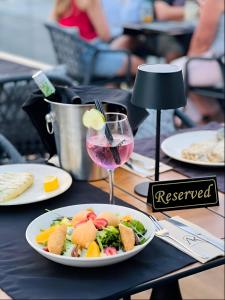 a table with a plate of food and a glass of wine at Adeti Residence in Nesebar