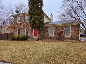 a brick house with a red door on a yard at 3 bedroom 3 bath lovely home in Aurora IL in Aurora