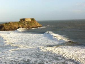a building on an island in the ocean at East Trewent Farm in Pembroke