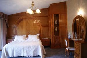 een slaapkamer met een wit bed en een houten muur bij Quintaesencia Hotel Boutique in Huasca de Ocampo