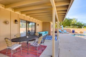 a patio with a table and chairs next to a pool at Private Pool & Fire Pit! Walkable Tucson Retreat in Tucson