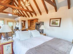 une chambre avec un grand lit avec des draps blancs dans l'établissement Romantic Carmel Cottage Ocean Country Views, à Carmel