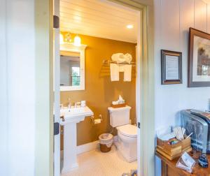 une salle de bain avec des toilettes blanches et un lavabo dans l'établissement Romantic Carmel Cottage Ocean Country Views, à Carmel