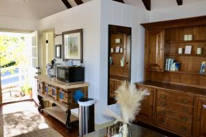 Cette chambre dispose d'armoires en bois et d'un comptoir avec un four micro-ondes. dans l'établissement Romantic Carmel Cottage Ocean Country Views, à Carmel