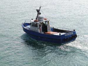 a blue and white boat in the water at East Trewent Farm in Pembroke