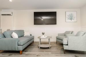 a living room with two couches and a tv at 2003 Queen Suite, 2nd Floor Cove in Surf City