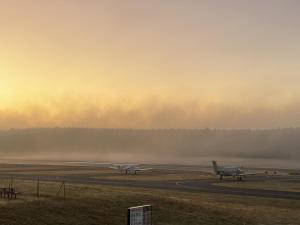 Zwei Flugzeuge stehen im Nebel auf einer Flughafenlandebahn. in der Unterkunft Tower Lodge in Schönhagen