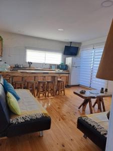 a living room with a couch and a kitchen at La cabaña del Oso in La Boca +5 photos