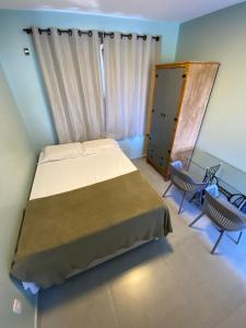Un dormitorio con una cama y dos sillas. en Casa Solar, en Florianópolis