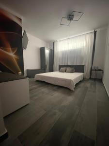 a bedroom with a bed and wooden floors at O5 residence in Nivy