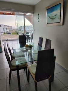 a dining room with a glass table and chairs at Condominio Las Terrazas in Asia