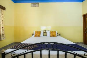 ein Schlafzimmer mit einem Bett mit gelben Wänden in der Unterkunft SPOT ON Cherish Guest House in Ranchi